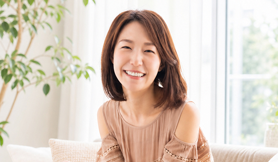 姿勢が良くなったとうれしそうに微笑む40代女性